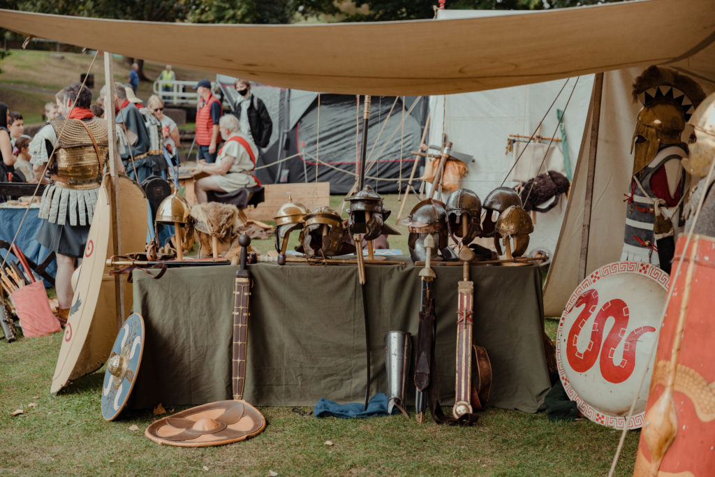 Roman stall displaying helmets, swords and shields.