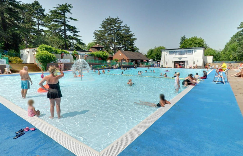 People enjoying Droitwich Spa lido, an outdoor pool in Lido Park. 